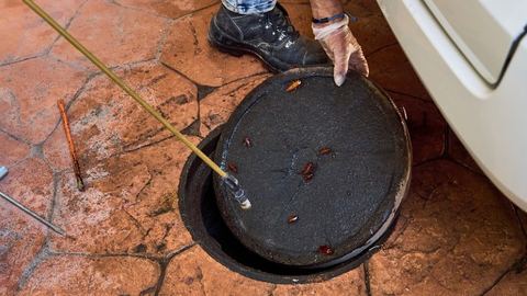Técnico abriendo la tapa de una arqueta técnica durante una revisión de prevención de legionela en León